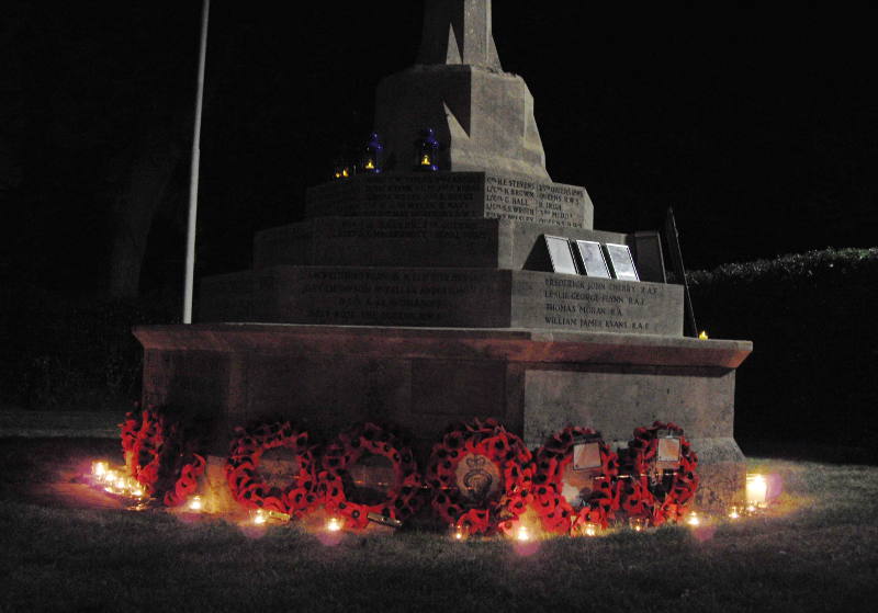 stone war memorial with wreaths and candles